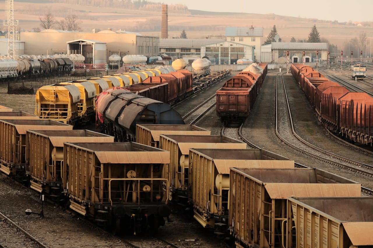 services-01 A busy freight train yard with multiple tracks and a variety of train cars in a rural setting.